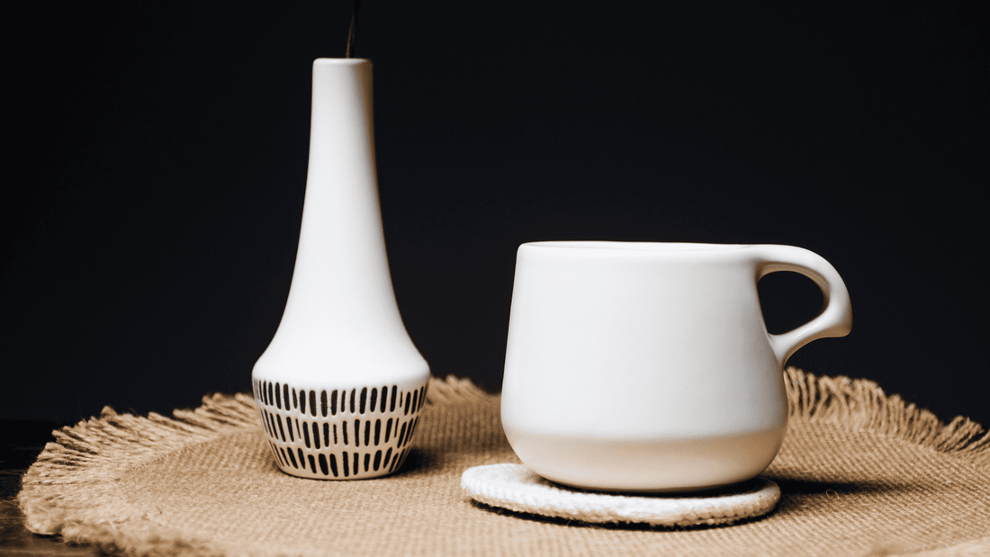 A coffee mug with a pitcher next to it