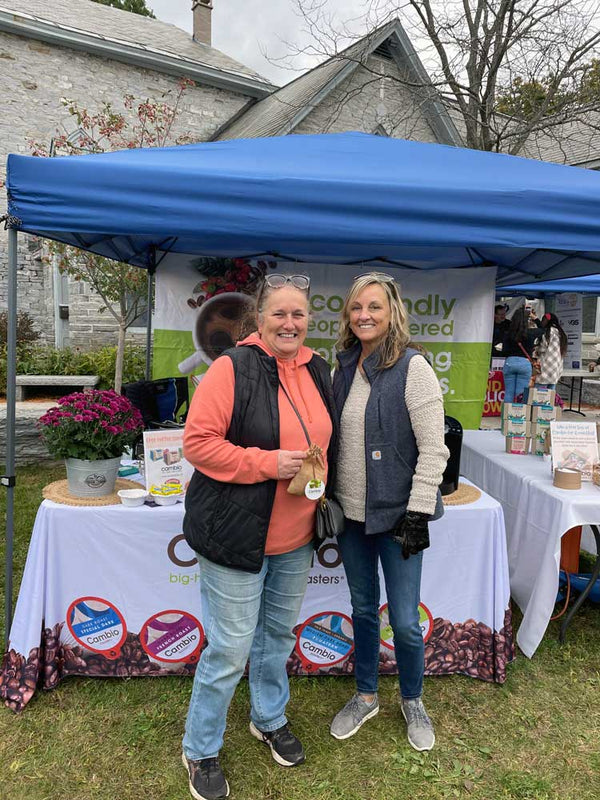 two ladies in front of a cambio roasters table