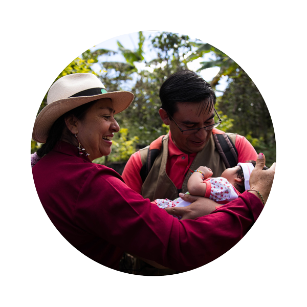 two people holding a baby in the woods