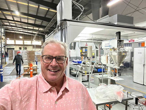 owner of cambio posing in front of cambio coffee machines