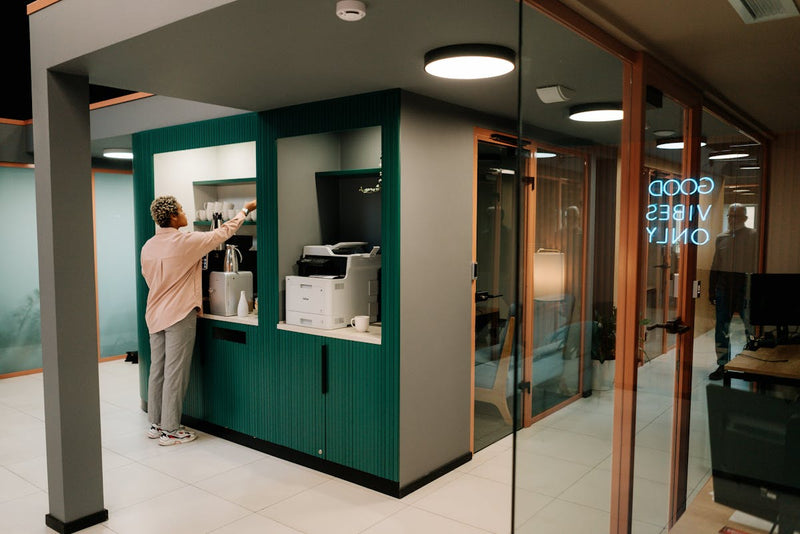 person getting some coffee in a break room in their office