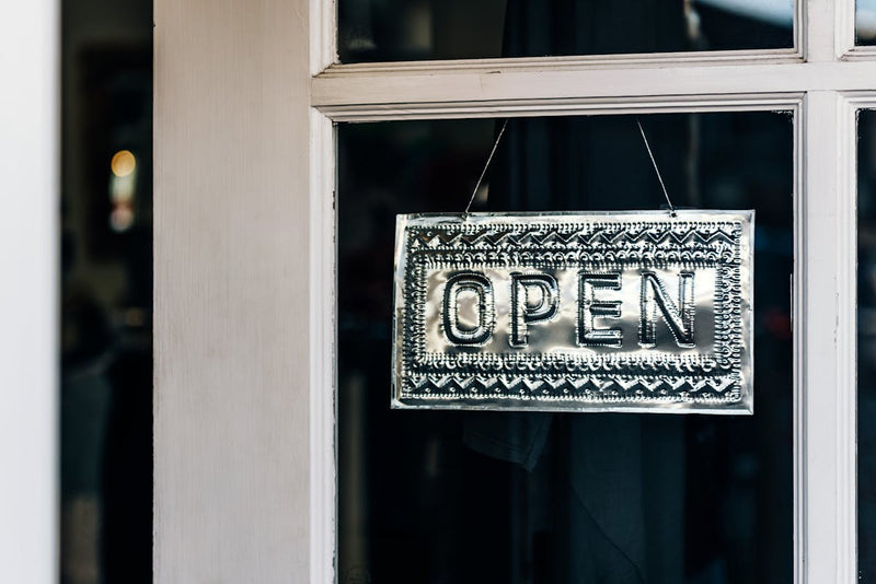 an open sign on a door of a small business
