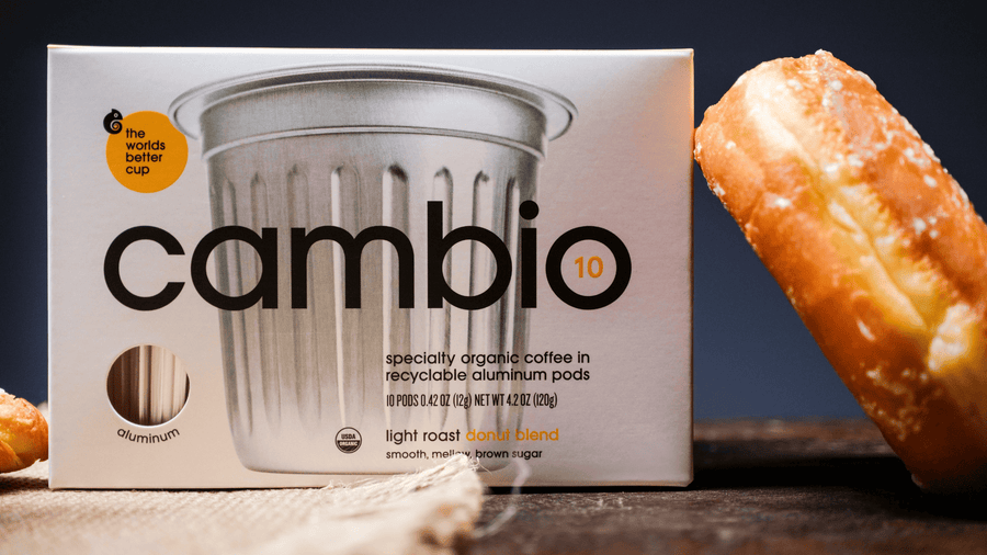 A box of aluminum cambio pods with a donut leaning on it