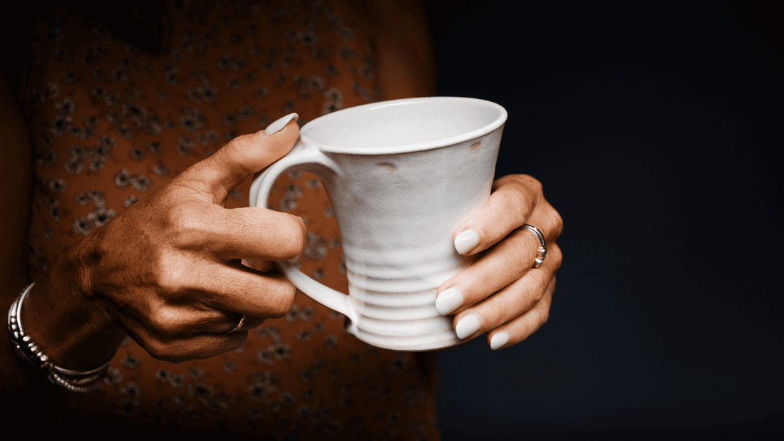 Lady holding a coffee mug with coffee in it
