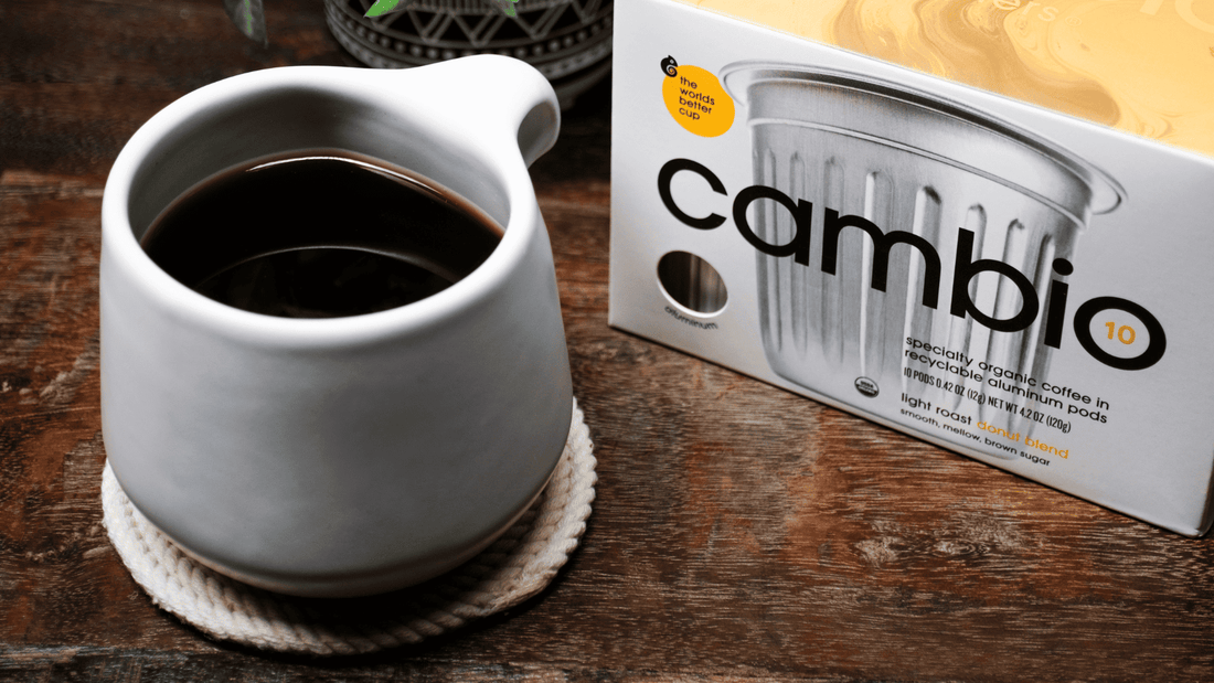 A cambio coffee pod box next to a cup of coffee