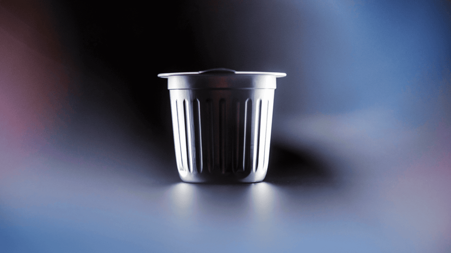 An aluminum coffee pod against a blurred backround