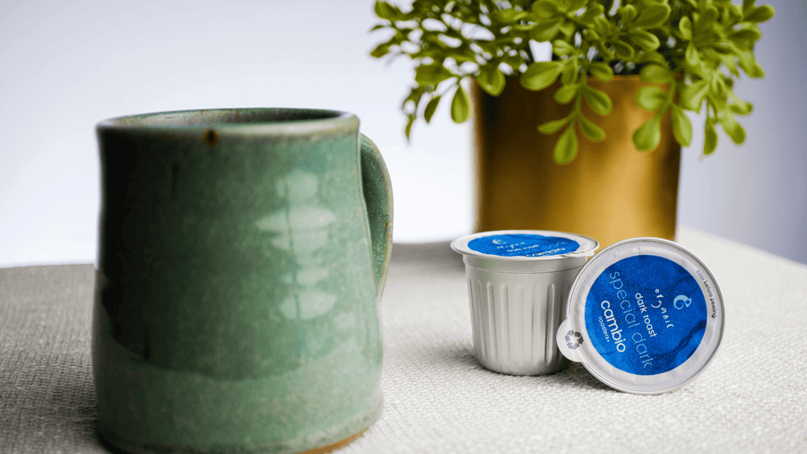 A coffee mug with aluminum coffee pods next to it