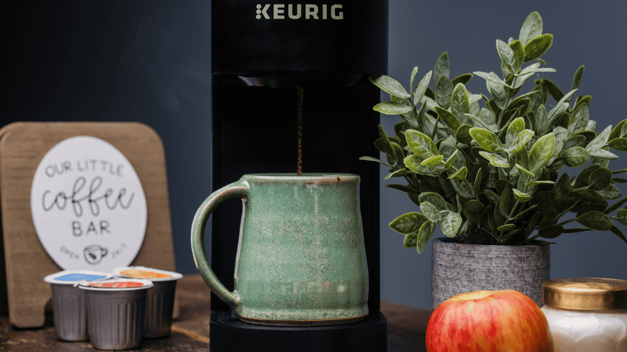 A coffee mug sitting on a keurig ready to brew