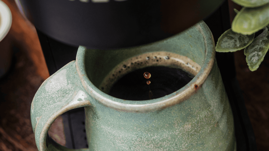 A mug being filled up with freshly brewed coffee