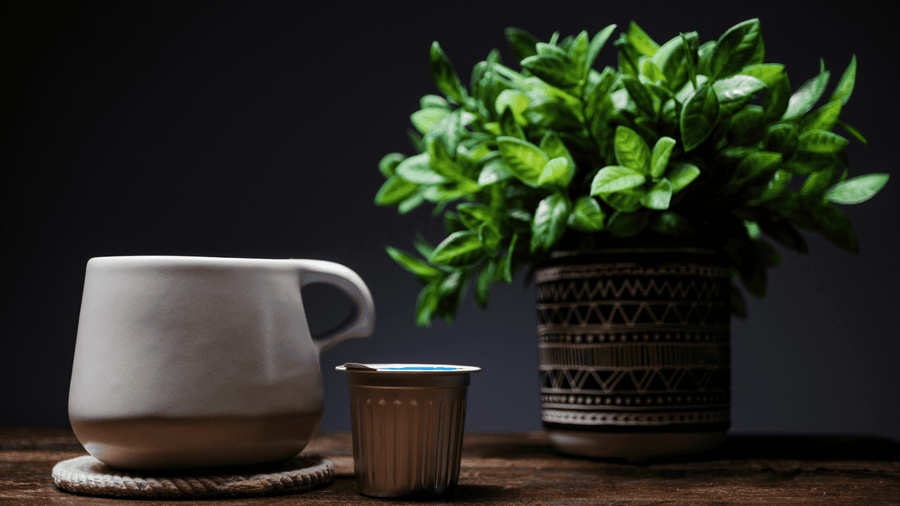 A coffee mug with an aluminum coffee pod next to it
