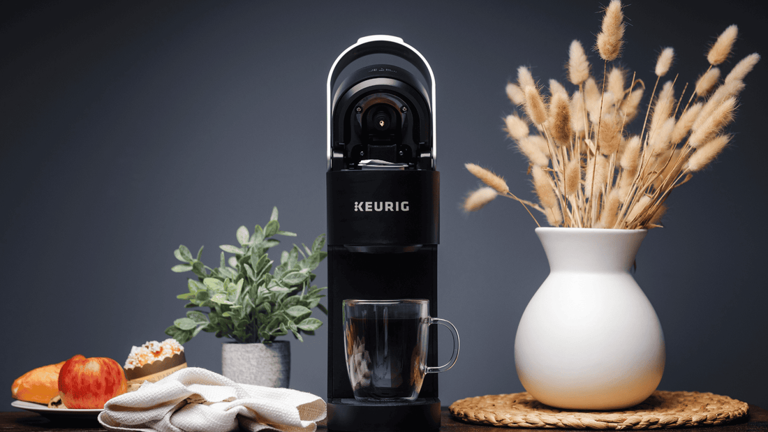 A keurig with freshly brewed coffee in a mug underneath it