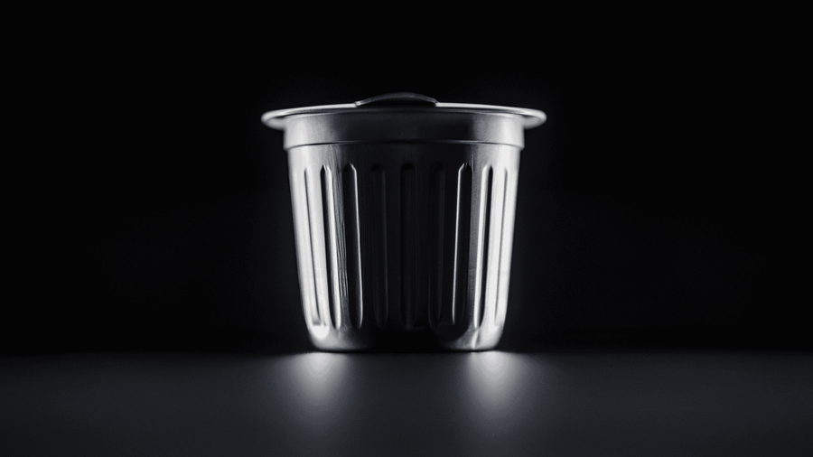 a cambio aluminum coffee pod up against a black backround