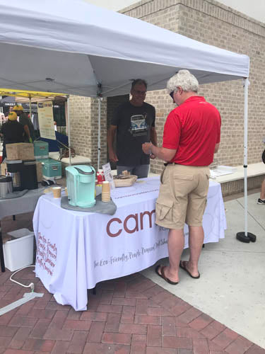 man checking out a table with cambio roasters on it