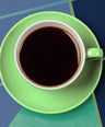 Green cup and saucer with black coffee on a blue geometric background